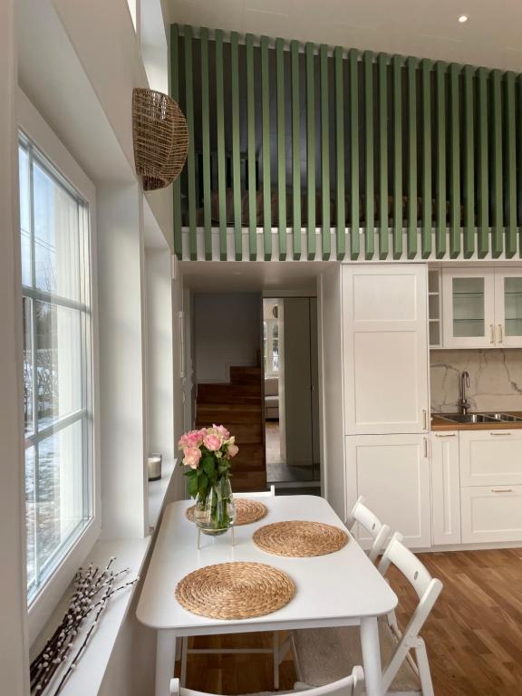 Ett nytt fräsch hus utanför Stockholm nära Arlanda في Rosersberg: مطبخ مع طاولة بيضاء مع كرسيين