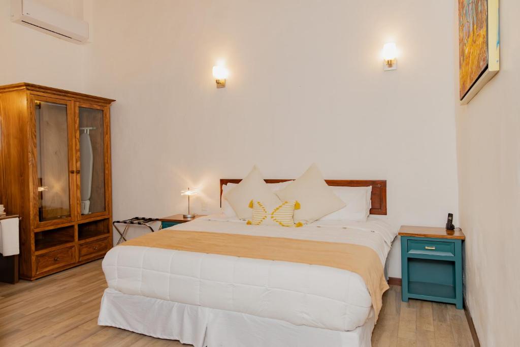 a bedroom with a large bed and a wooden cabinet at La Casona de Josefa in Querétaro