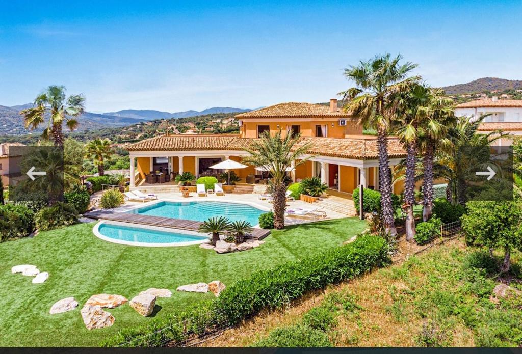 - une vue aérienne sur une maison avec une piscine et des palmiers dans l'établissement Superbe Villa avec vue mer panoramique - Villa Chelsea, à Sainte-Maxime