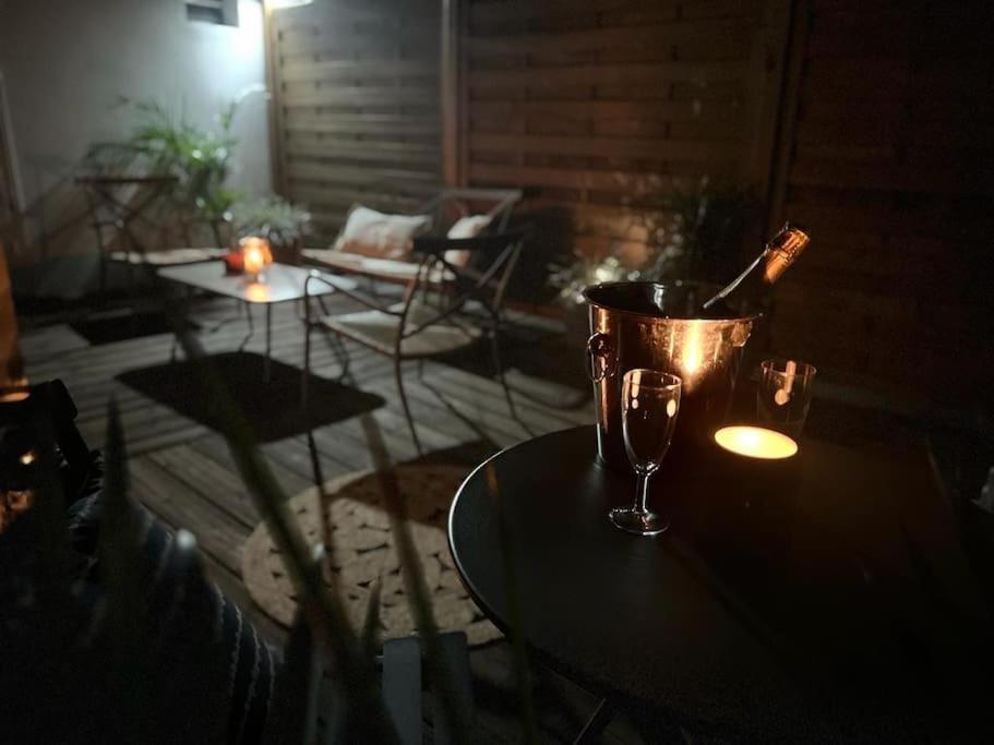 einen Tisch mit einem Eimer und einem Glas Wein darauf in der Unterkunft Le Pluméria - T1 avec un SPA privatif in Saint-Denis