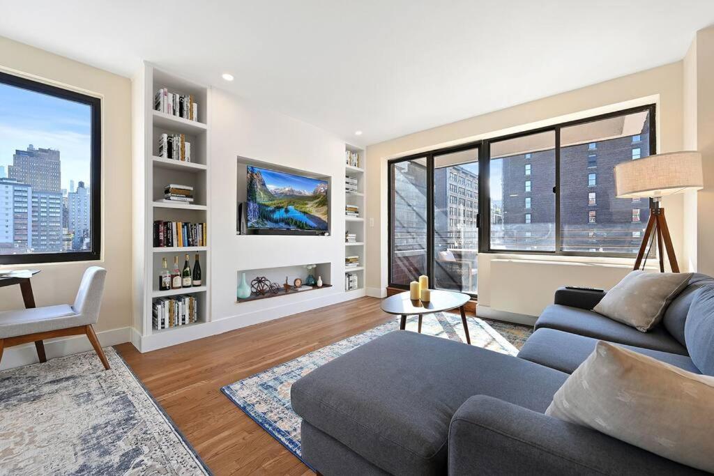 a living room with a couch and large windows at Modern one bedroom with private balcony in New York