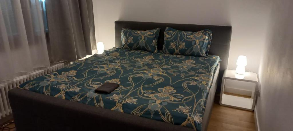 a bedroom with a bed with a blue and gold bedspread at CASA ANA Apartament 1 in Câmpulung Moldovenesc