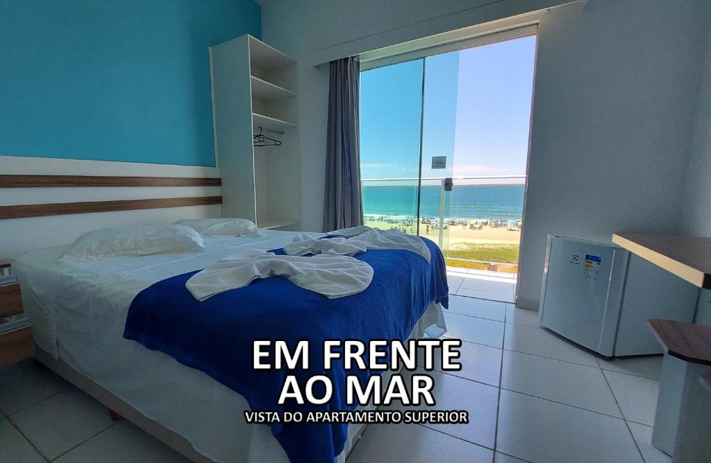 グァラトゥバにあるHotel Pousada Agua Marinhaのベッドルーム1室(ベッド1台付)、海を望む大きな窓が備わります。