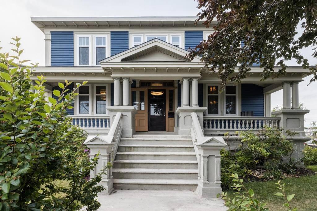 una casa azul con escaleras que conducen a la puerta principal en Duff Heritage House, en St. John's