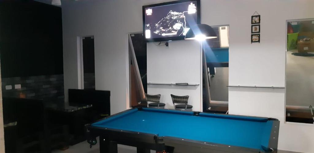 um quarto com uma mesa de bilhar e uma televisão em Sobrado Itapoa sc em Itapoá