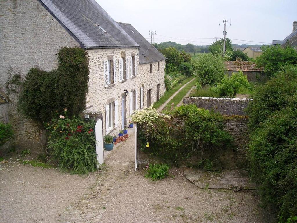 uma antiga casa de tijolos com um jardim em frente em Maison de 3 chambres avec wifi a Fontenay sur Mer em Fontenay-sur-Mer