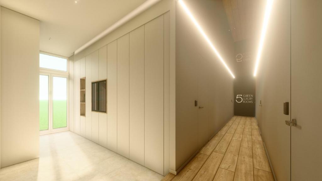 un couloir vide avec un mur blanc et une porte dans l'établissement 5GreenLuxurieRooms, à Turin