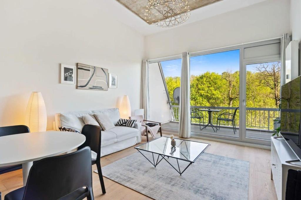 a living room with a white couch and a table at Elegant 1BR Apt, Balcony, Pool, Central Location in Luxembourg