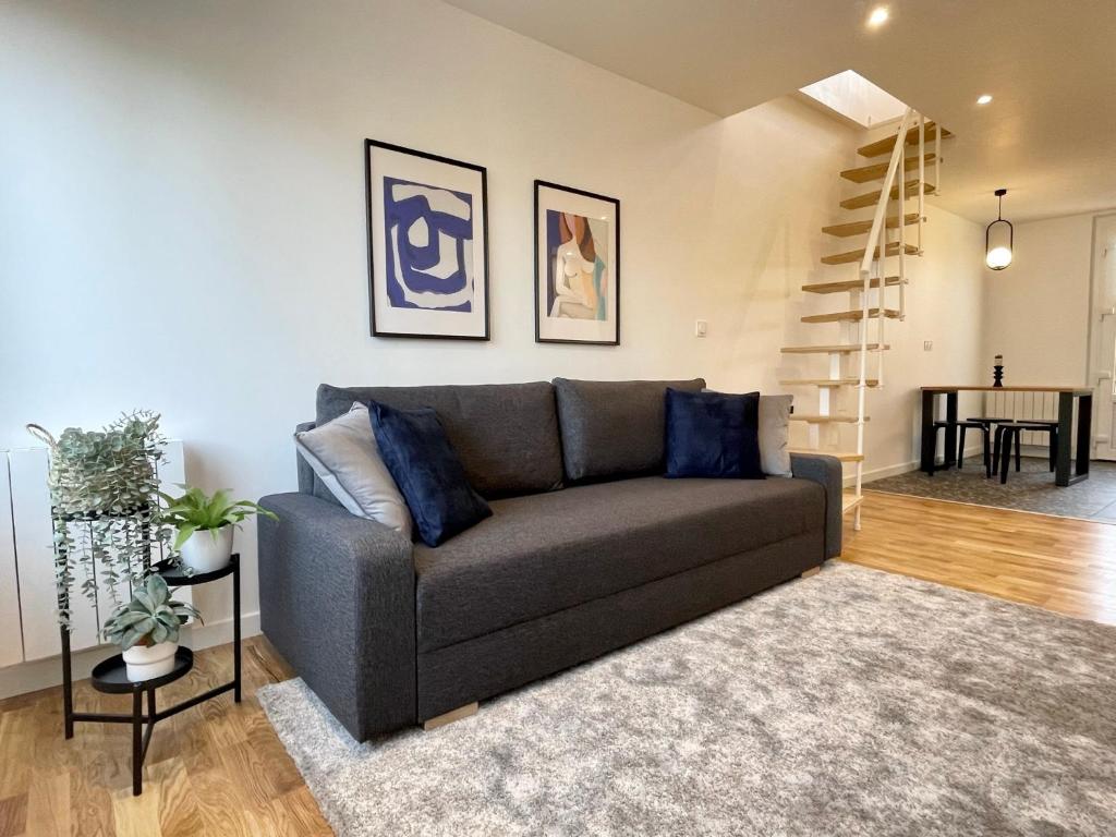 a living room with a couch and a staircase at Appartement dans une maison cosy in Chartres