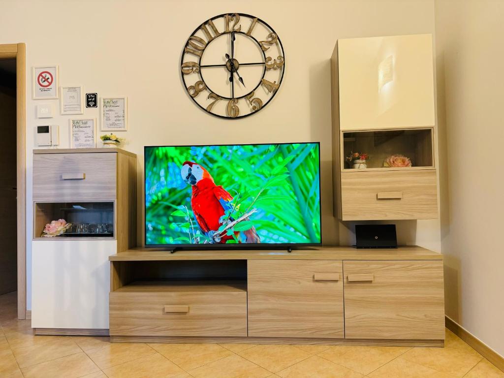 une télévision avec un perroquet et une horloge dans l'établissement Sweet Home, à Lissone
