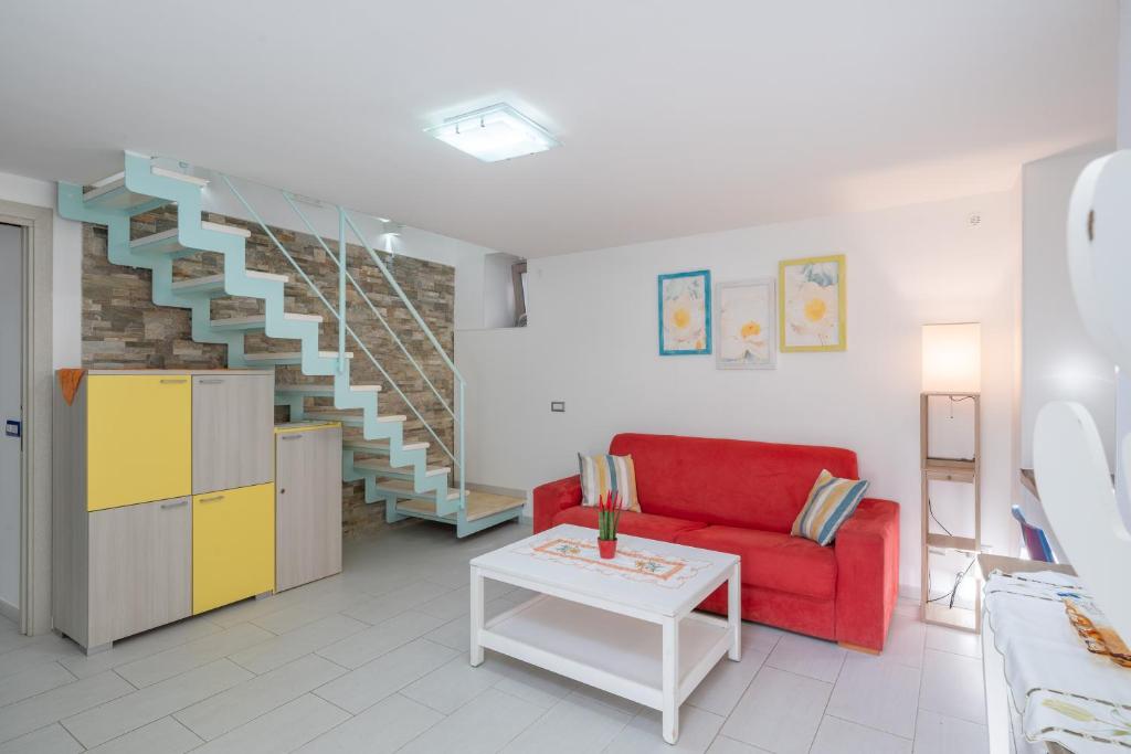 uma sala de estar com um sofá vermelho e uma escada em [Amalfi Coast]Elegant house in Penisola Sorrentina em Vico Equense