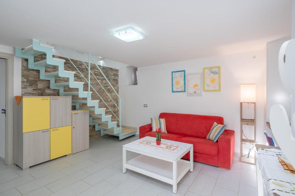a living room with a red couch and a staircase at [Amalfi Coast]Elegant house in Penisola Sorrentina in Vico Equense