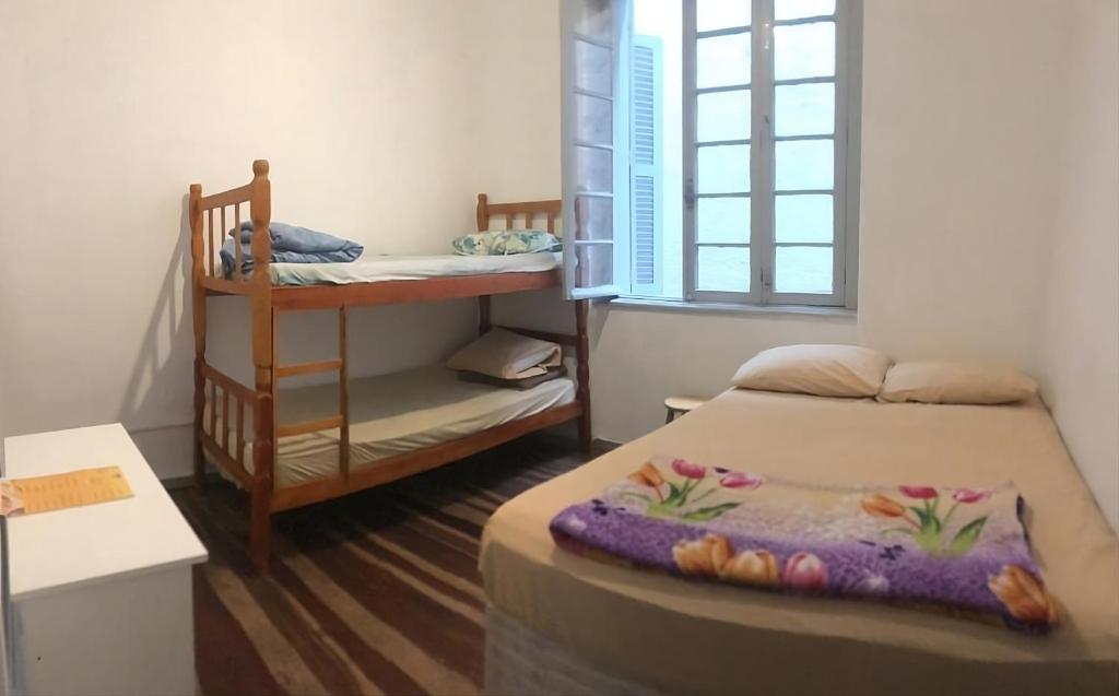 ポルト・アレグレにあるHostel Bahiaの小さな客室で、ベッド1台と二段ベッド1組が備わります。