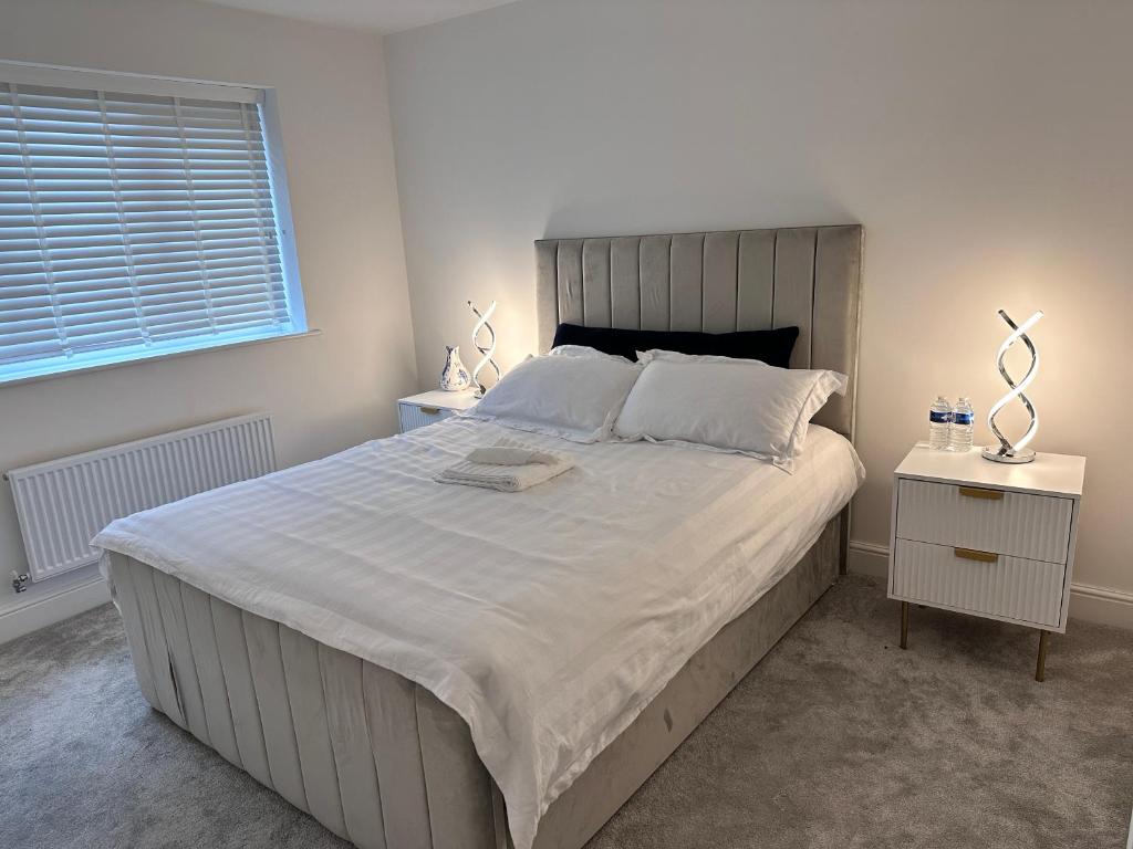 a bedroom with a large white bed with two night stands at Stylish Lux in Morley