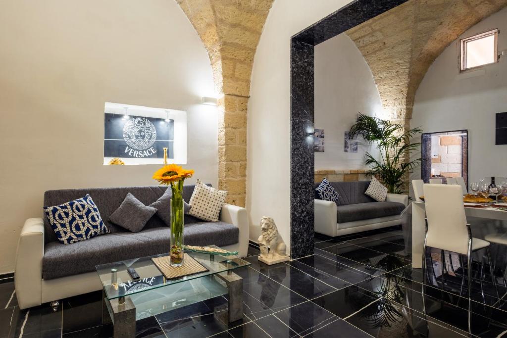 uma sala de estar com um sofá e uma mesa em Charme Palace Salento em Salice Salentino