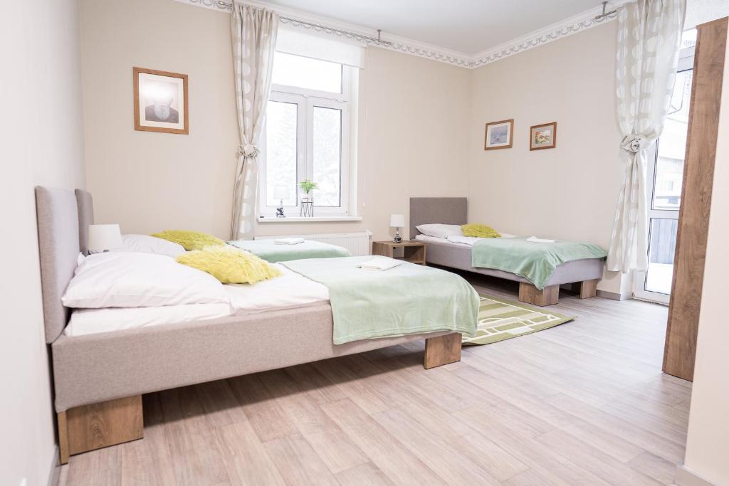 a white room with two beds in it at Mazurek - pokoje do wynajęcia in Duszniki Zdrój