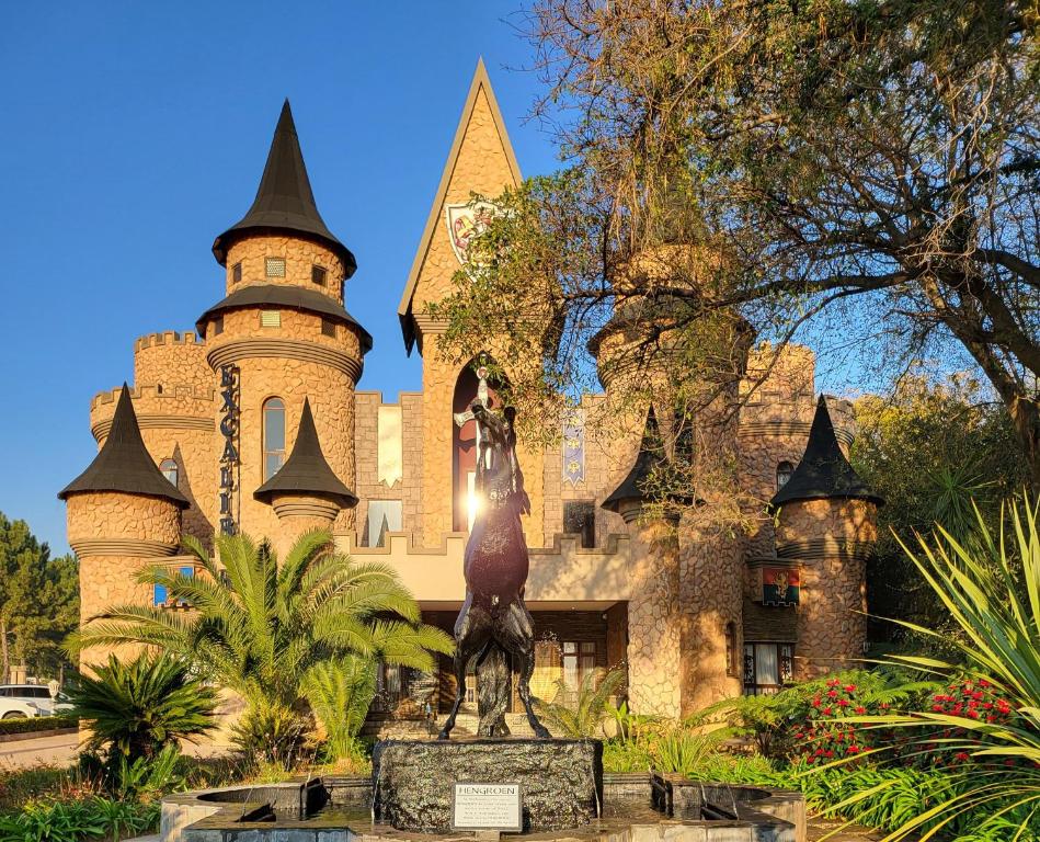 un château avec une statue en face dans l'établissement Excalibur Boutique Hotel, à Rustenburg