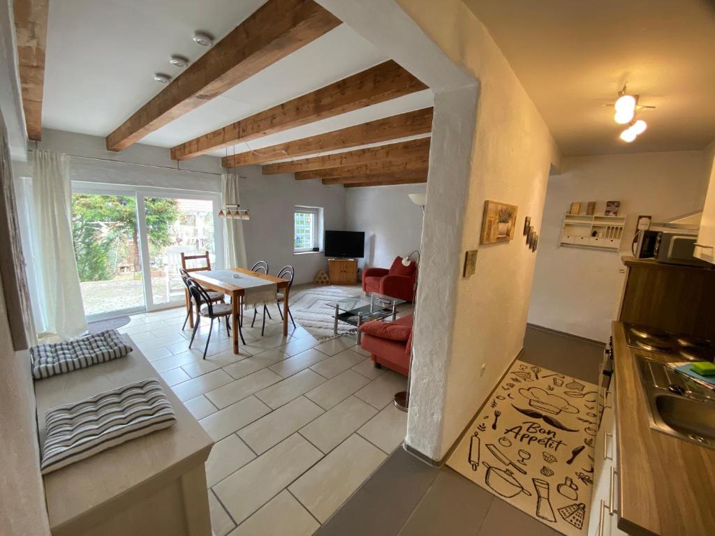 a kitchen and a living room with a table at Ferienwohnung mit schöner Terrasse. in Ellerstadt