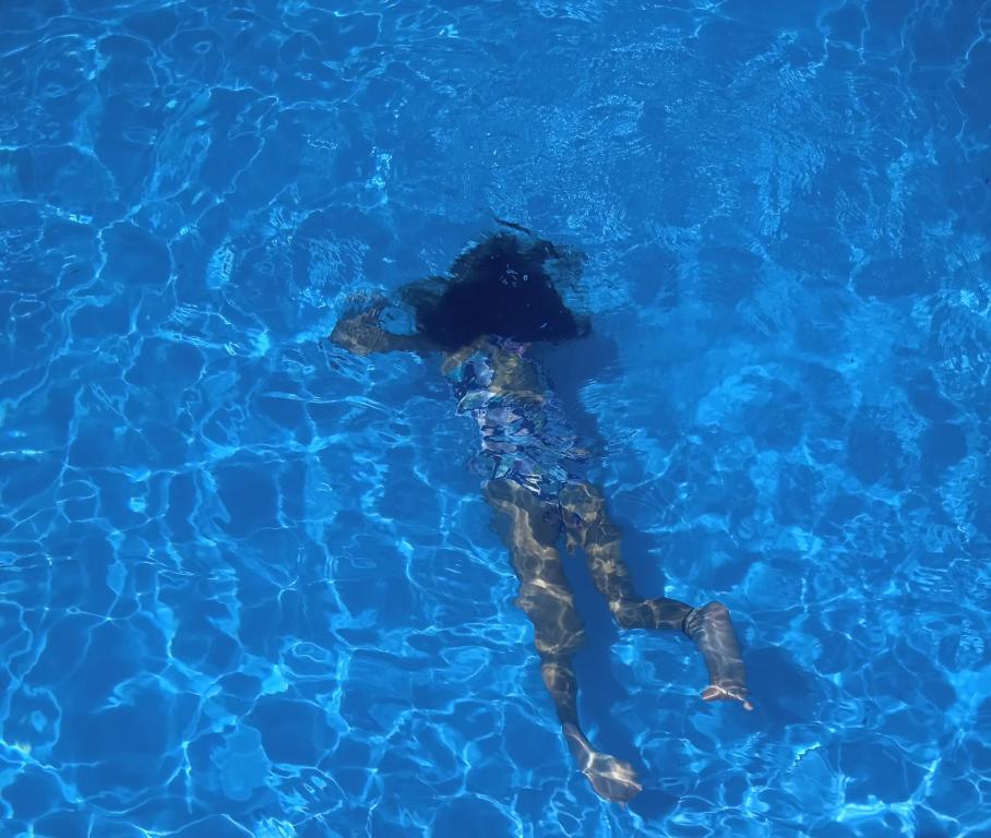una persona nadando en una piscina de agua azul en Casa Los Trinos en Lobos