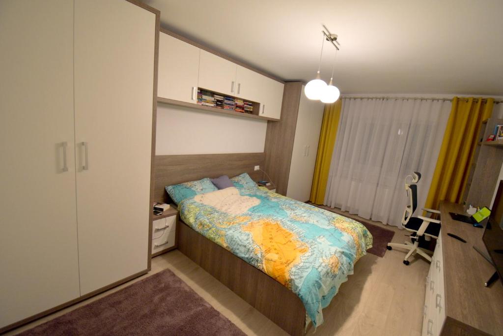 een kleine slaapkamer met een bed en een bureau bij CozinessApart in Boekarest