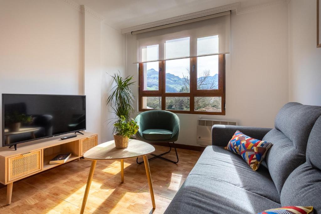 sala de estar con sofá y TV en Apartamento Balcón de Liérganes en Liérganes