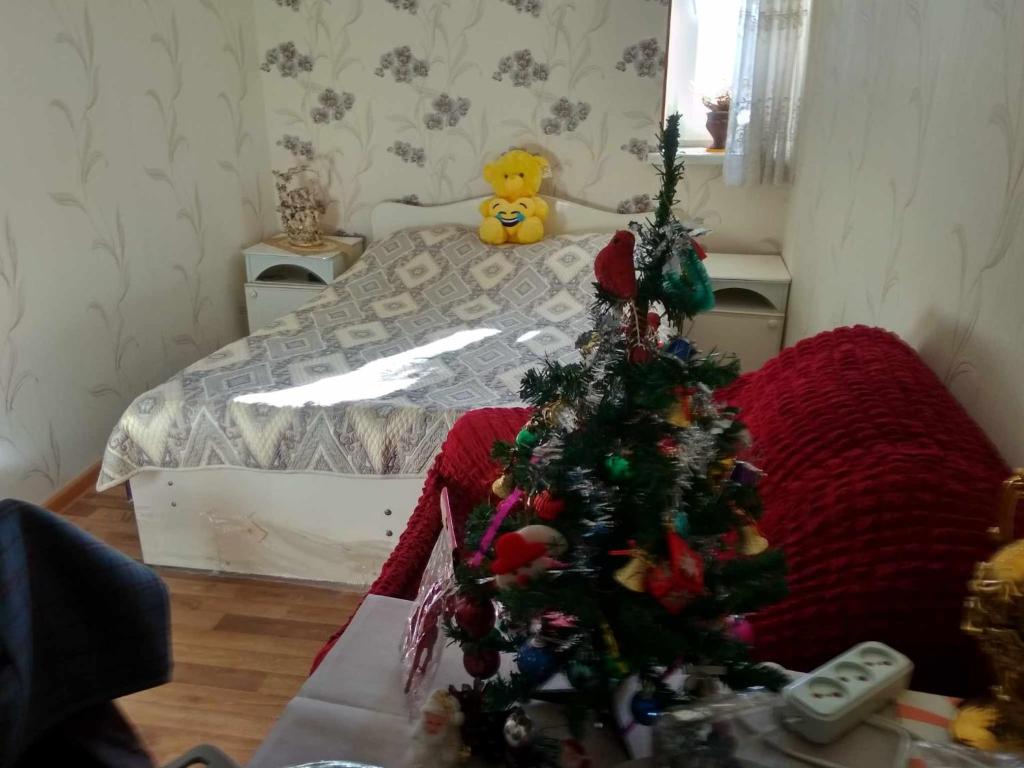 a room with a christmas tree on a bed at Guest House Dodo in Stepantsminda