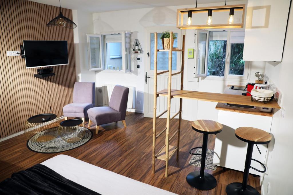 ein Wohnzimmer mit einer Küche und ein Wohnzimmer mit einem Tisch in der Unterkunft Eiffel Tour Cosy chesterfield in Paris