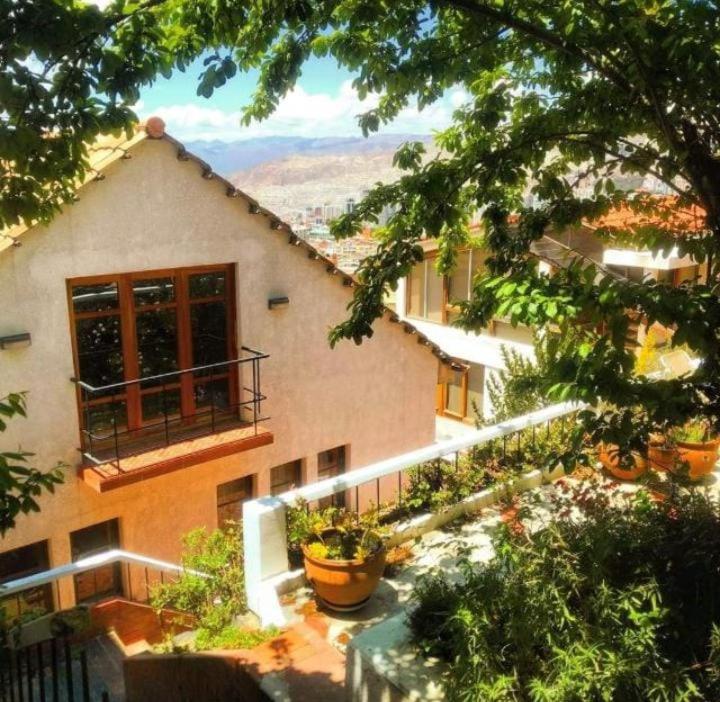una casa con balcón y plantas frente a ella en Villa Florita en La Paz