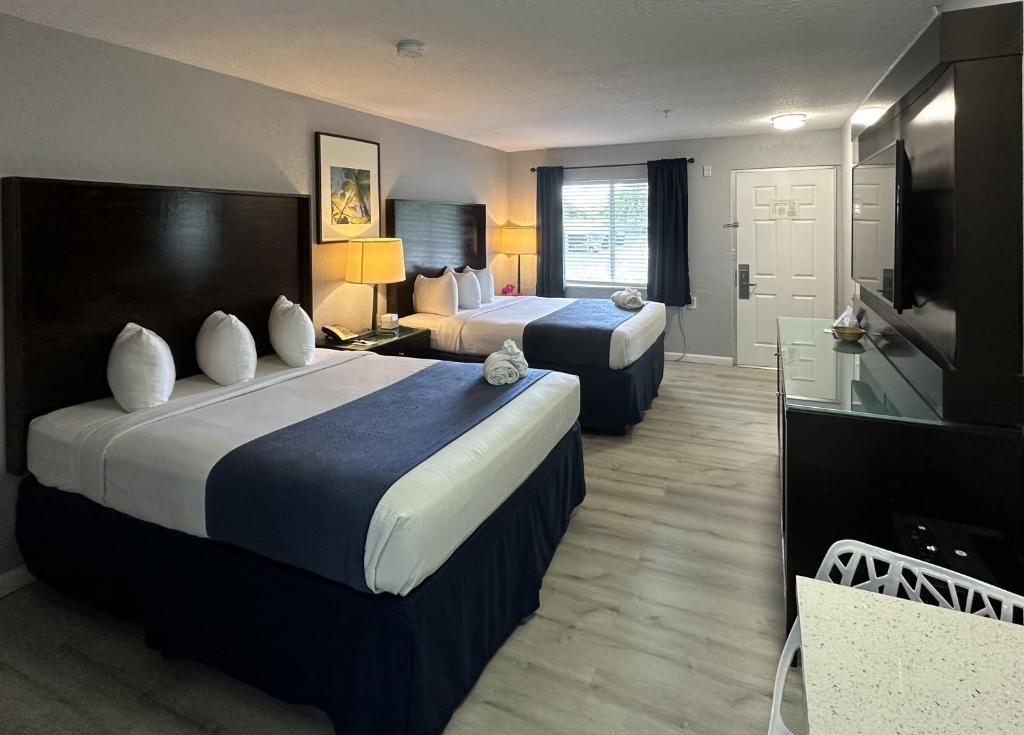 サラソタにあるLantern Inn & Suites - Sarasotaのベッド2台とテレビが備わるホテルルームです。