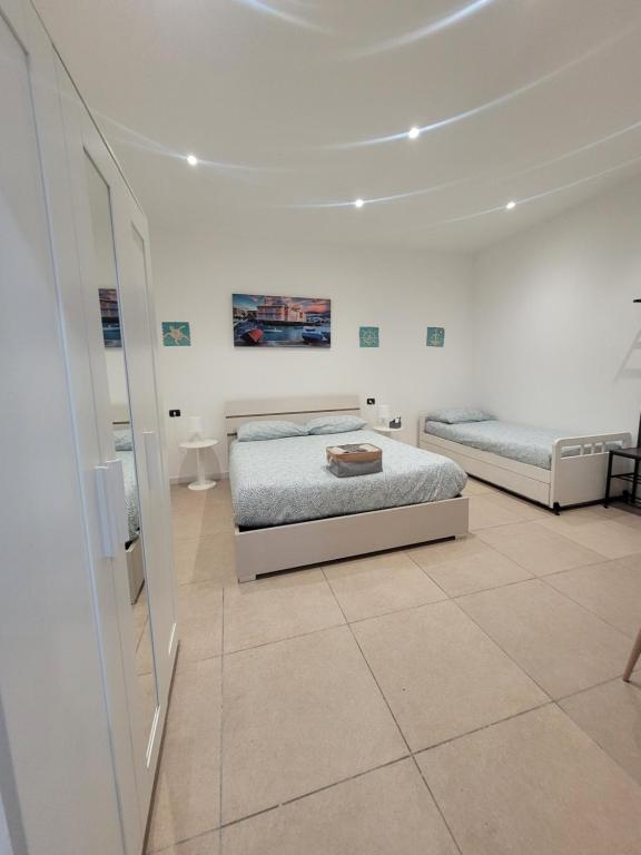 a white room with two beds and a mirror at House del Levante in Bari