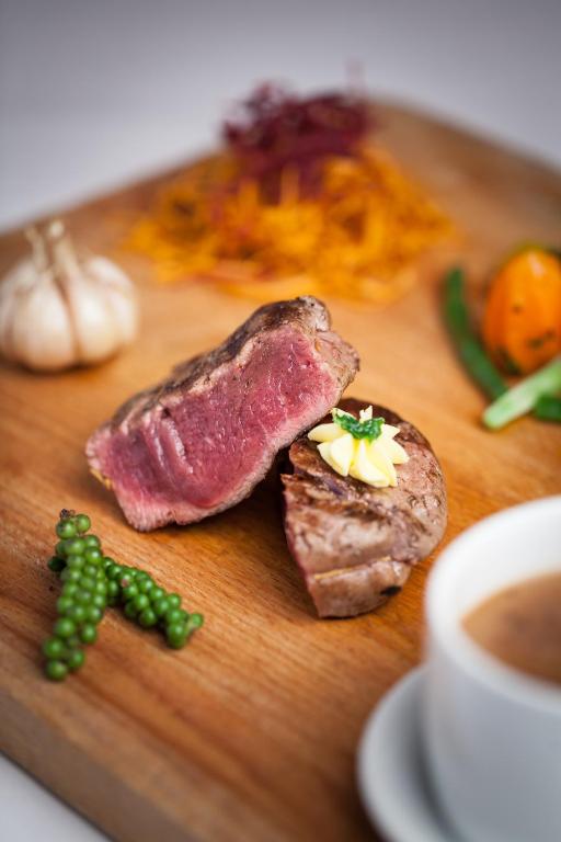 a wooden cutting board with meat and vegetables and a cup of coffee at Prince Angkor Hotel & Spa in Siem Reap