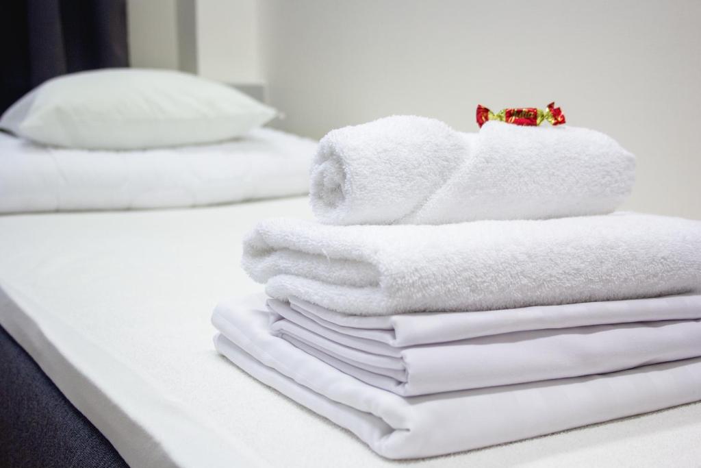 uma pilha de toalhas sentadas em cima de uma cama em Hostel Hermanni em Kuopio
