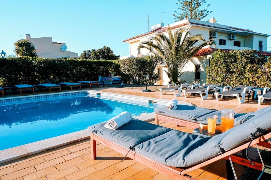 een zwembad met ligstoelen naast een huis bij Villa Miracampo - Elegant Secret in Albufeira