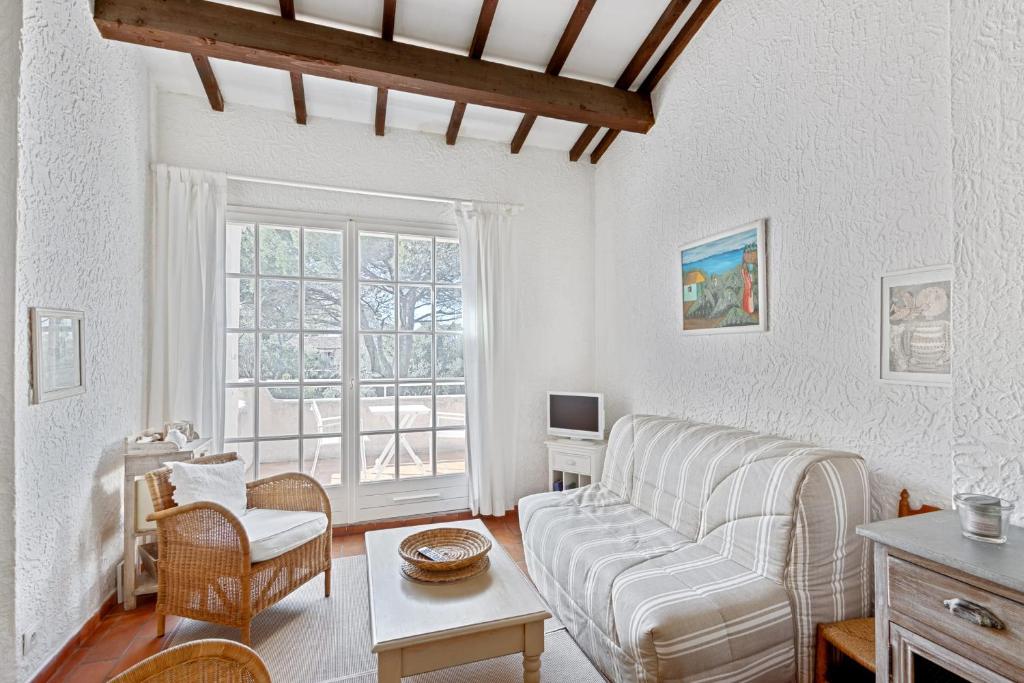 un salon avec un canapé et une table dans l'établissement Le Mas des Oliviers - Welkeys, à La Croix-Valmer