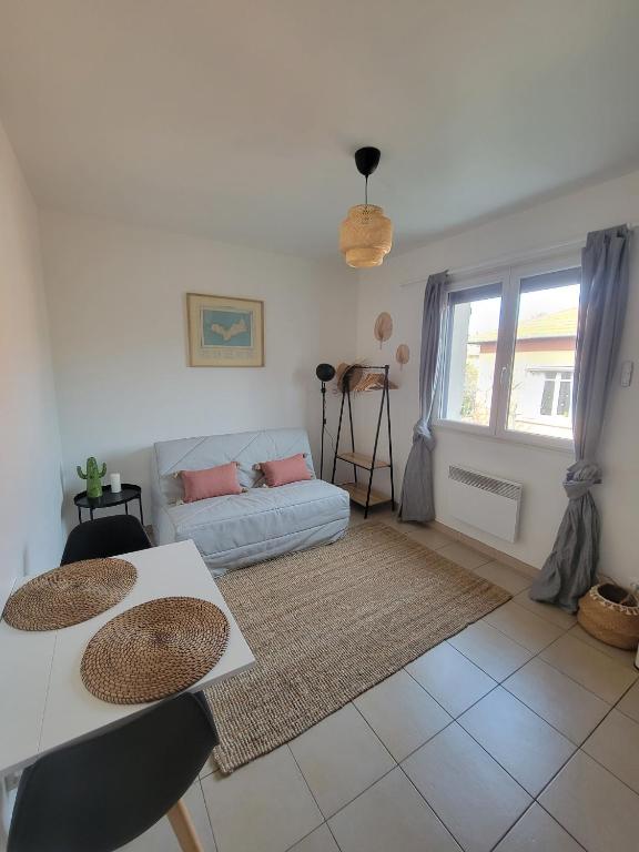 - un salon avec deux tables et un canapé dans l'établissement Joli studio lumineux centre avec parking securise dans quartier recherche, à Aix-en-Provence