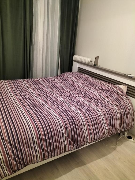 - un lit avec une couette rayée dans une chambre dans l'établissement Keva apartment, à Tours