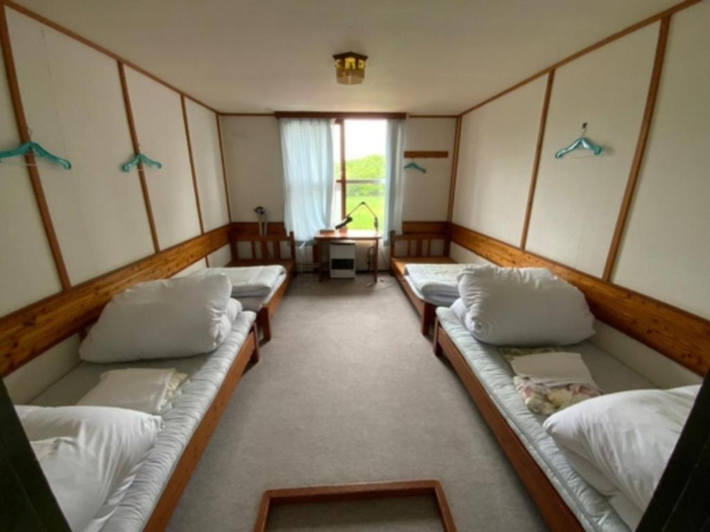 een kamer met meerdere banken in een kamer bij Mashuko Youth Hostel - Vacation STAY 00138v in Teshikaga
