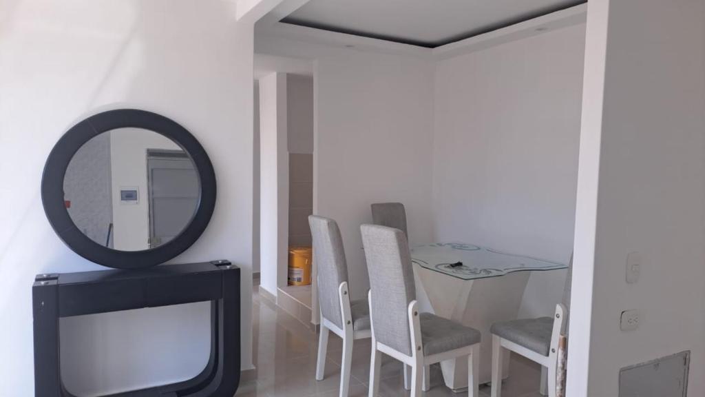 Apartamento في بارانكويلا: غرفة بها مرآة وتلفزيون وكراسي