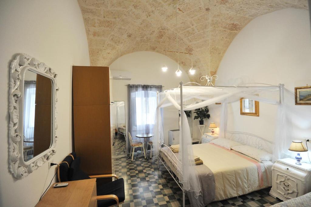 1 dormitorio con cama, espejo y mesa en B&B CASAVACANZE CHIESA MADRE, en Carovigno