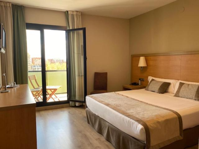 a hotel room with a bed and a balcony at Hotel Real in Lleida