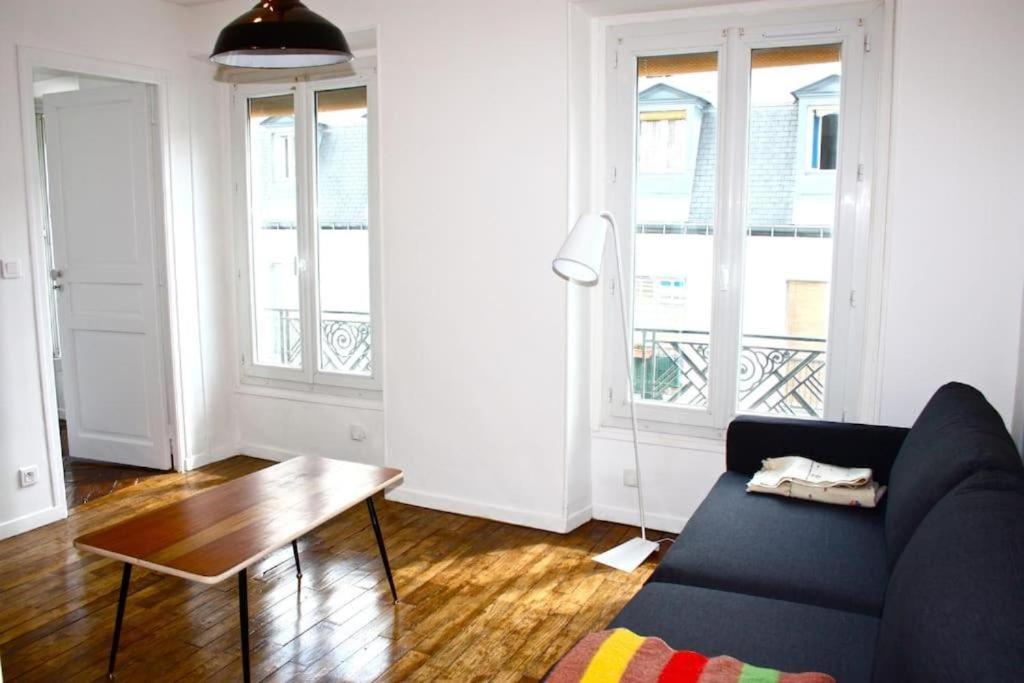 een woonkamer met een bank en een tafel bij Beautiful 1 bedroom in Le Marais in Parijs