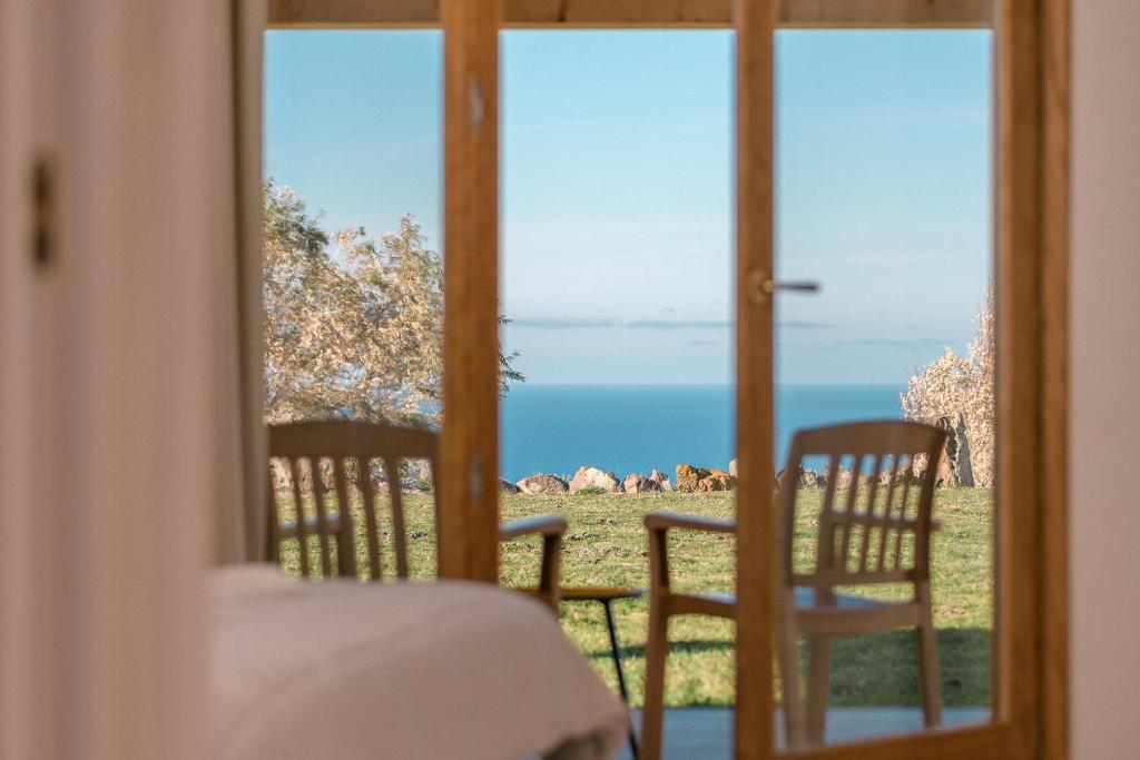 a room with a view of the ocean through a door at NEW SUITES SEA VIEW SARDINIA, Bedda Ista in Castelsardo
