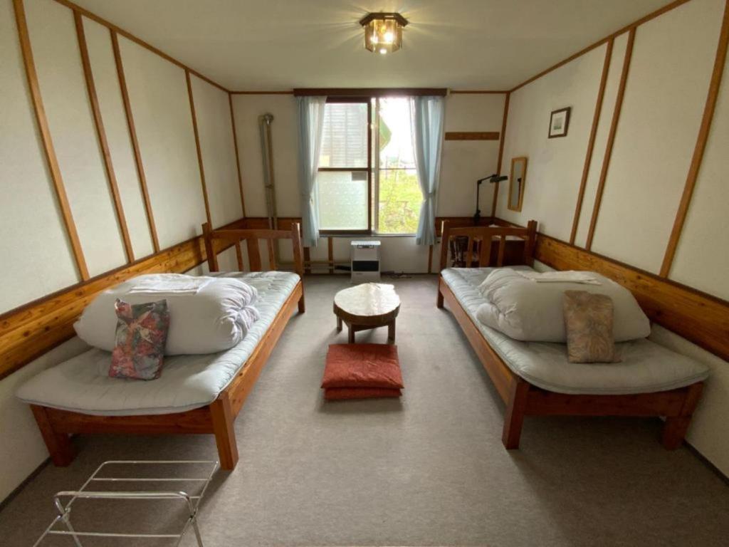 una camera con due letti e un tavolo e una finestra di Mashuko Youth Hostel - Vacation STAY 00246v a Teshikaga