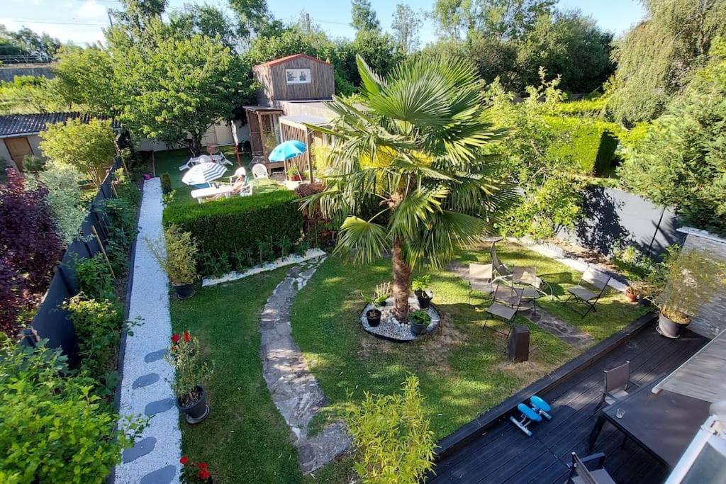 una vista aérea de un patio trasero con una palmera en studio GK15 GREENAPPART+ jardin SQY, Versailles.., en La Verrière