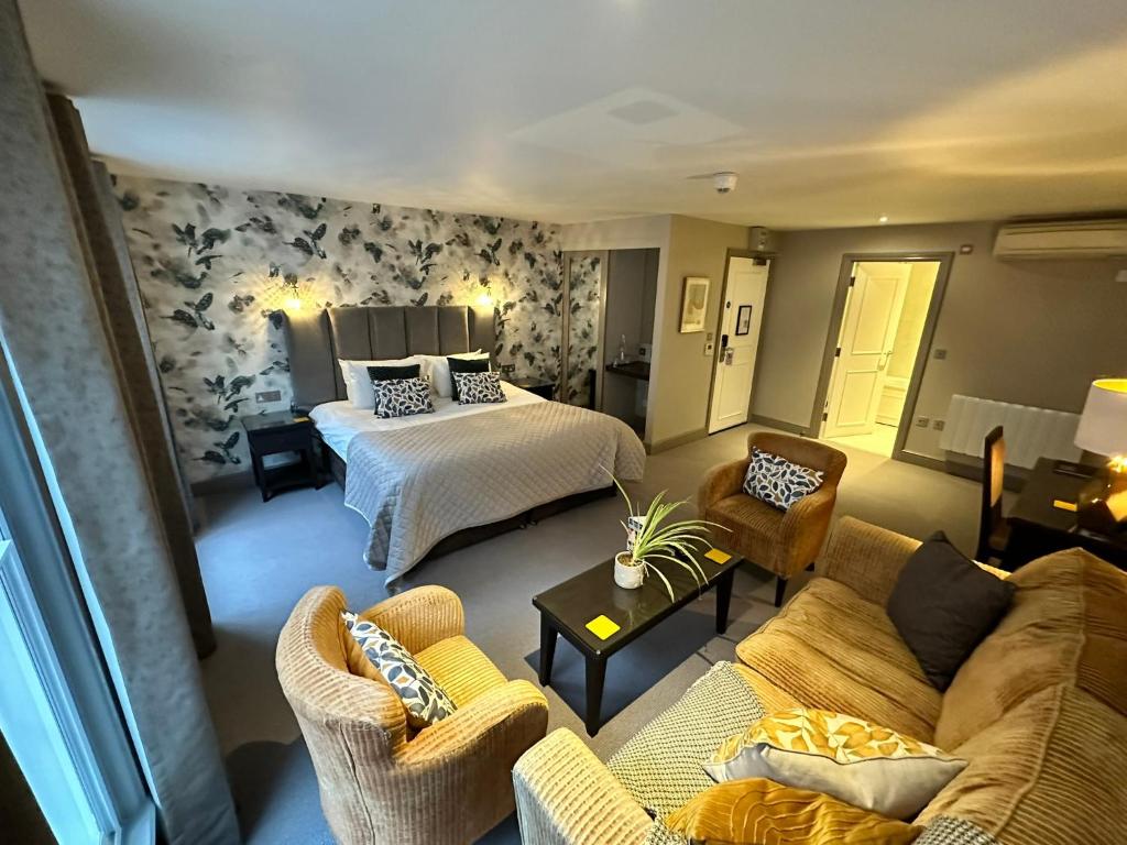 une chambre d'hôtel avec un lit, un canapé et des chaises dans l'établissement Goswell House, à Windsor