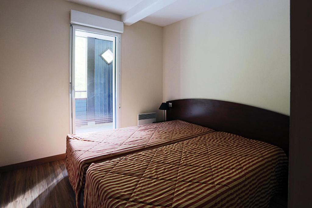 Schlafzimmer mit einem Bett und einem Fenster in der Unterkunft Résidence Serias - 2 Pièces pour 4 Personnes 594 in Germ