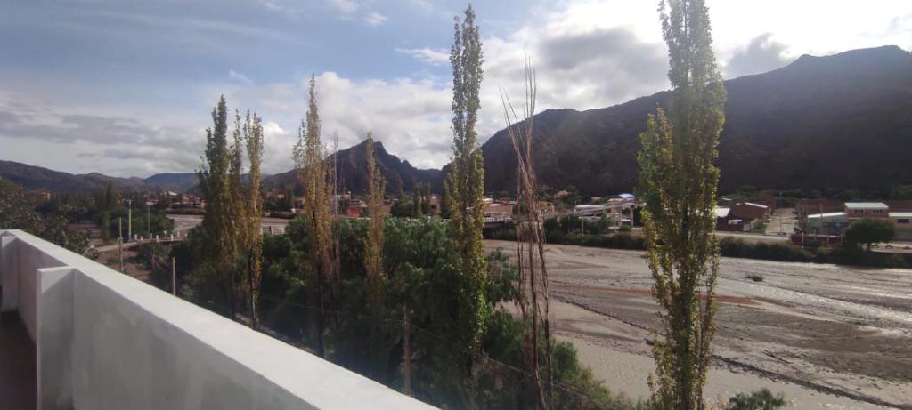 a view of a parking lot with trees and mountains at Hostal Cadena in Tupiza