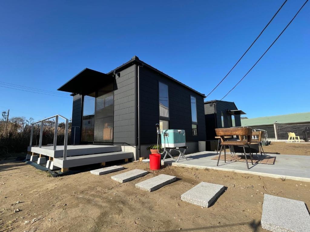 a black house with a bench and a table at HUCKLEBERRY GARDEN - Vacation STAY 94899v in Kujukuri