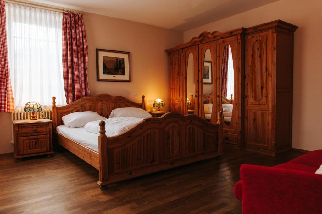 Un dormitorio con una cama de madera y un gran armario de madera. en Unertl Bräustüberl Gästehaus, en Haag in Oberbayern