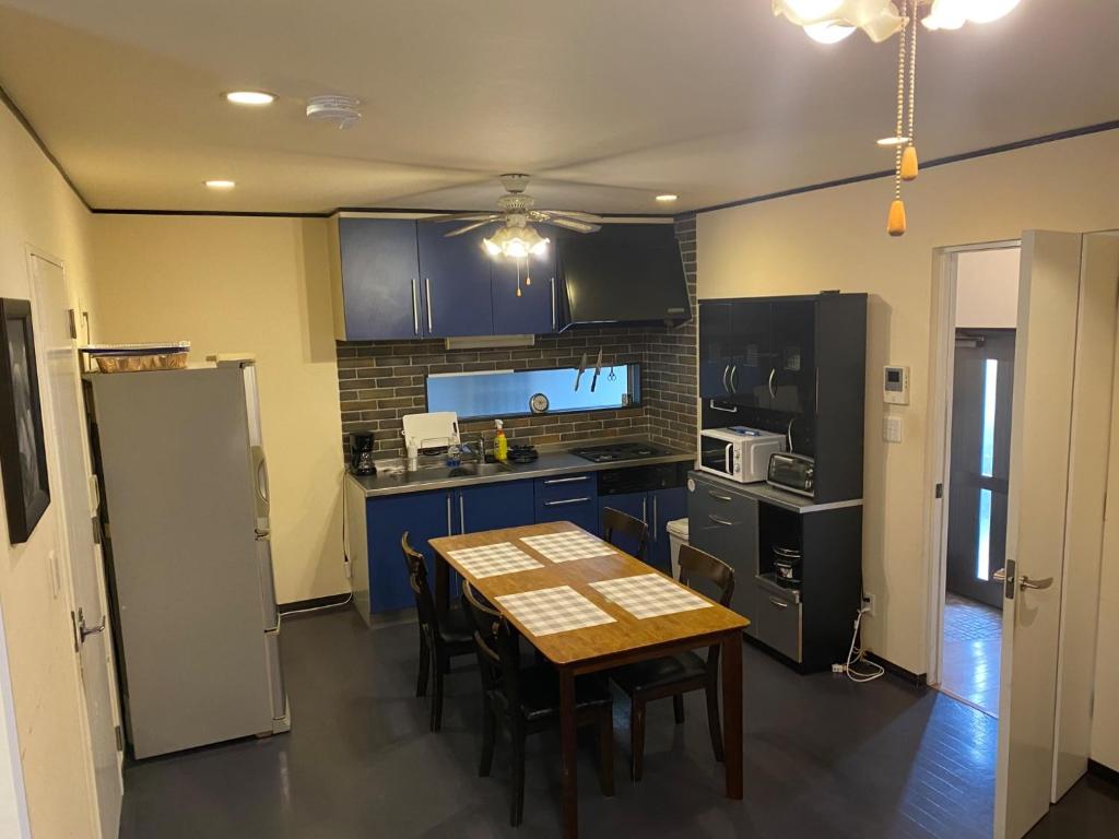a kitchen with a table with chairs and a refrigerator at Kami no Tsuki - Vacation STAY 15816 in Akiruno